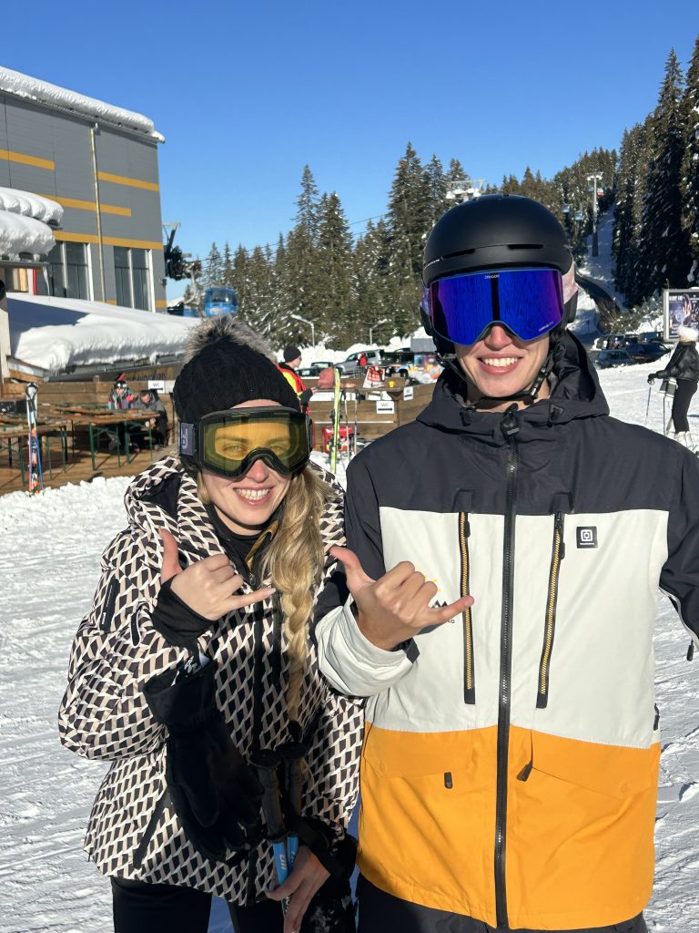 Two smiling skiers posing with shaka hand signs at Totem Ski Bansko